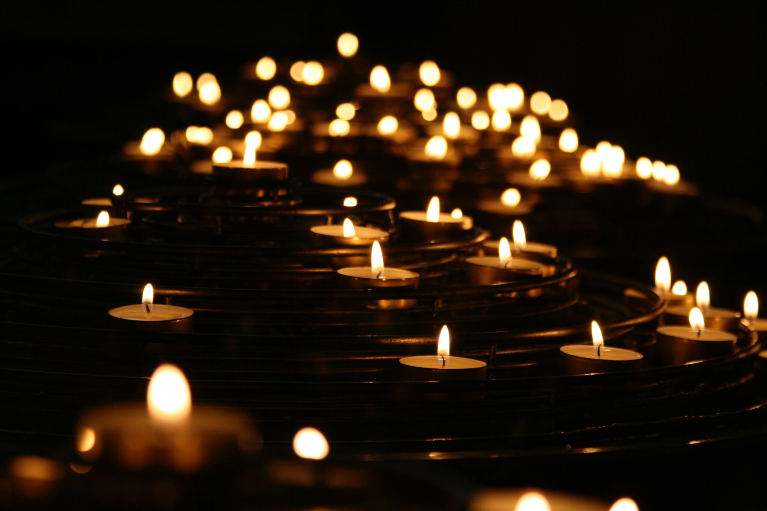 Candles lit floating in night pond